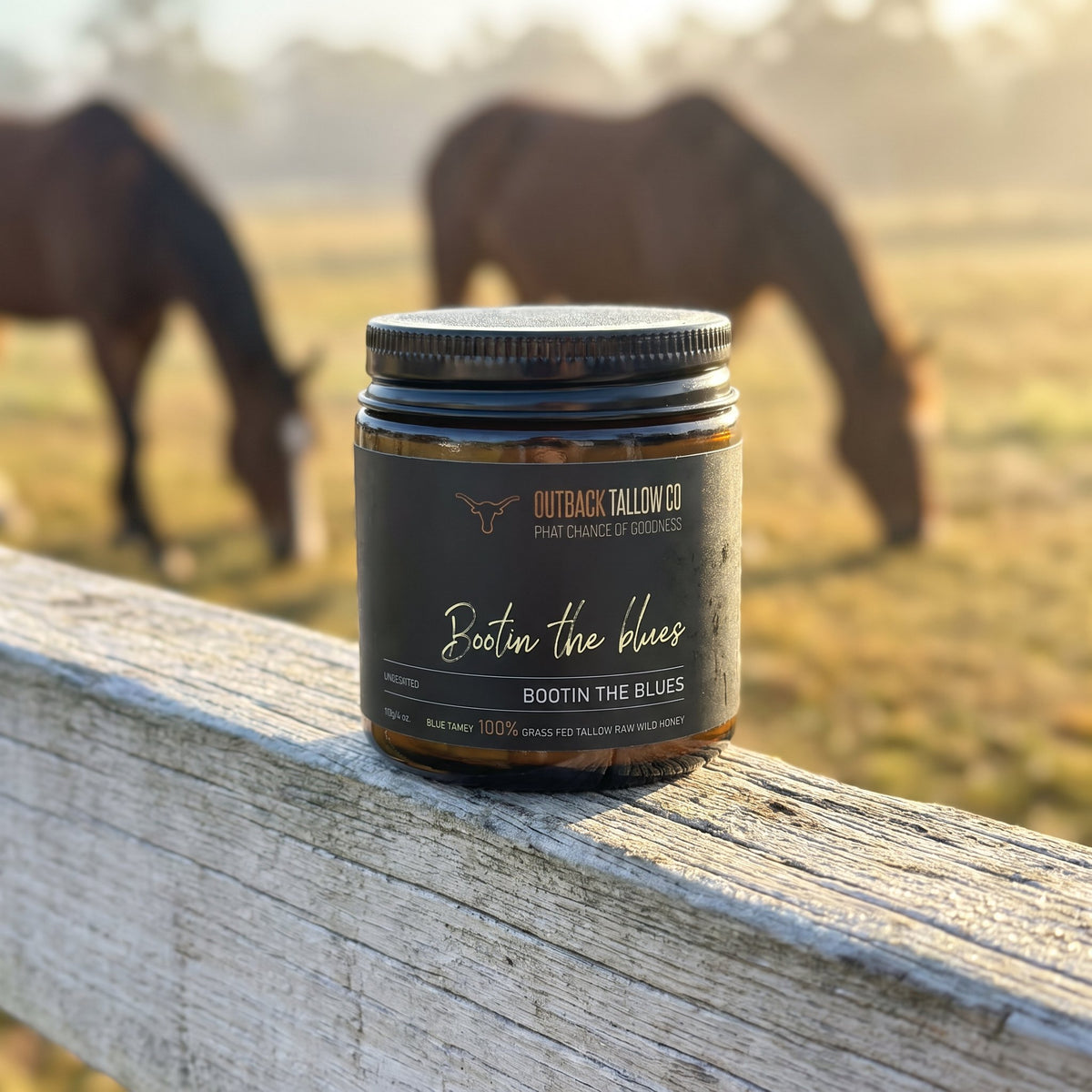 Bootin' the Blues jar on a fence rail with horses grazing behind (AI-generated image)