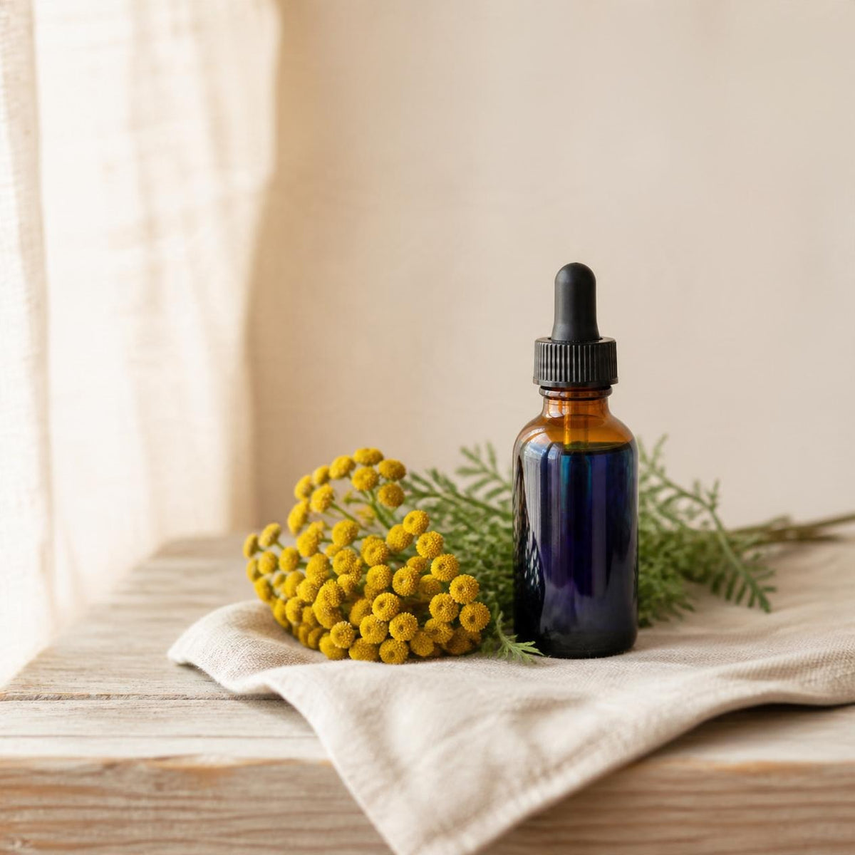 Blue tansy oil in a dropper bottle beside yellow blue tansy flowers, an ingredient in Bootin' the Blues whipped tallow balm. AI-generated image.