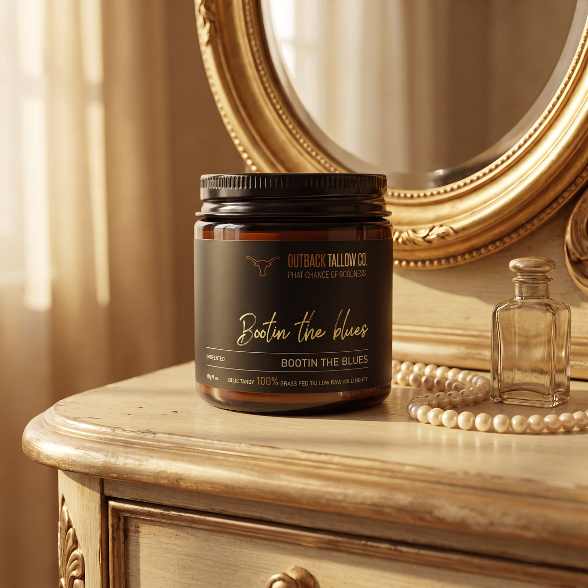 Bootin' the Blues whipped tallow balm jar on a vintage vanity with a gold mirror and pearls (AI-generated image)
