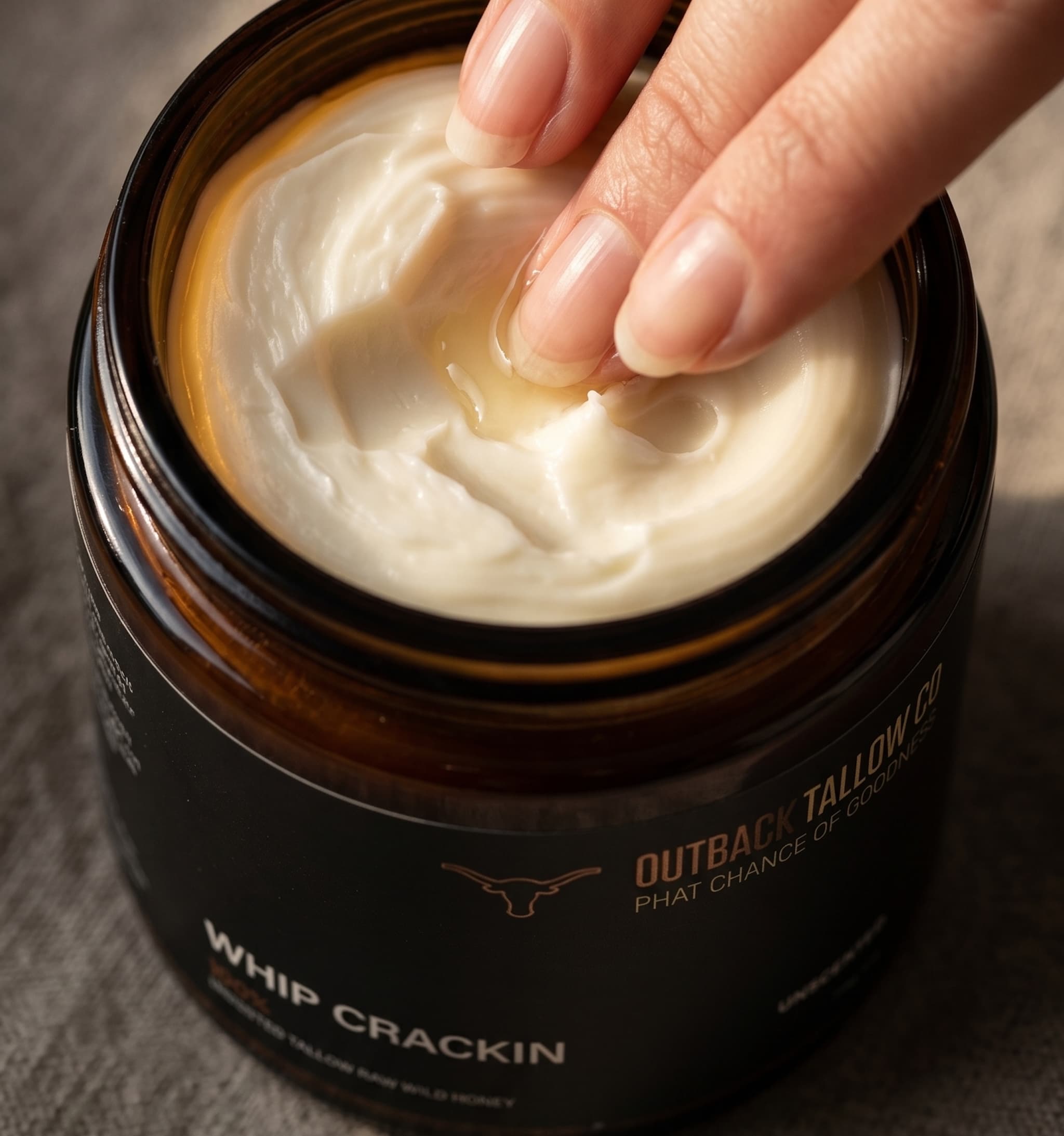 Jar of Outback Tallow Co. whip crackin whipped balm with a hand texture