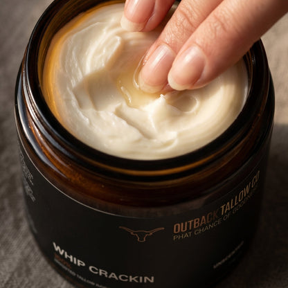Hand scooping whipped tallow from a jar labeled &